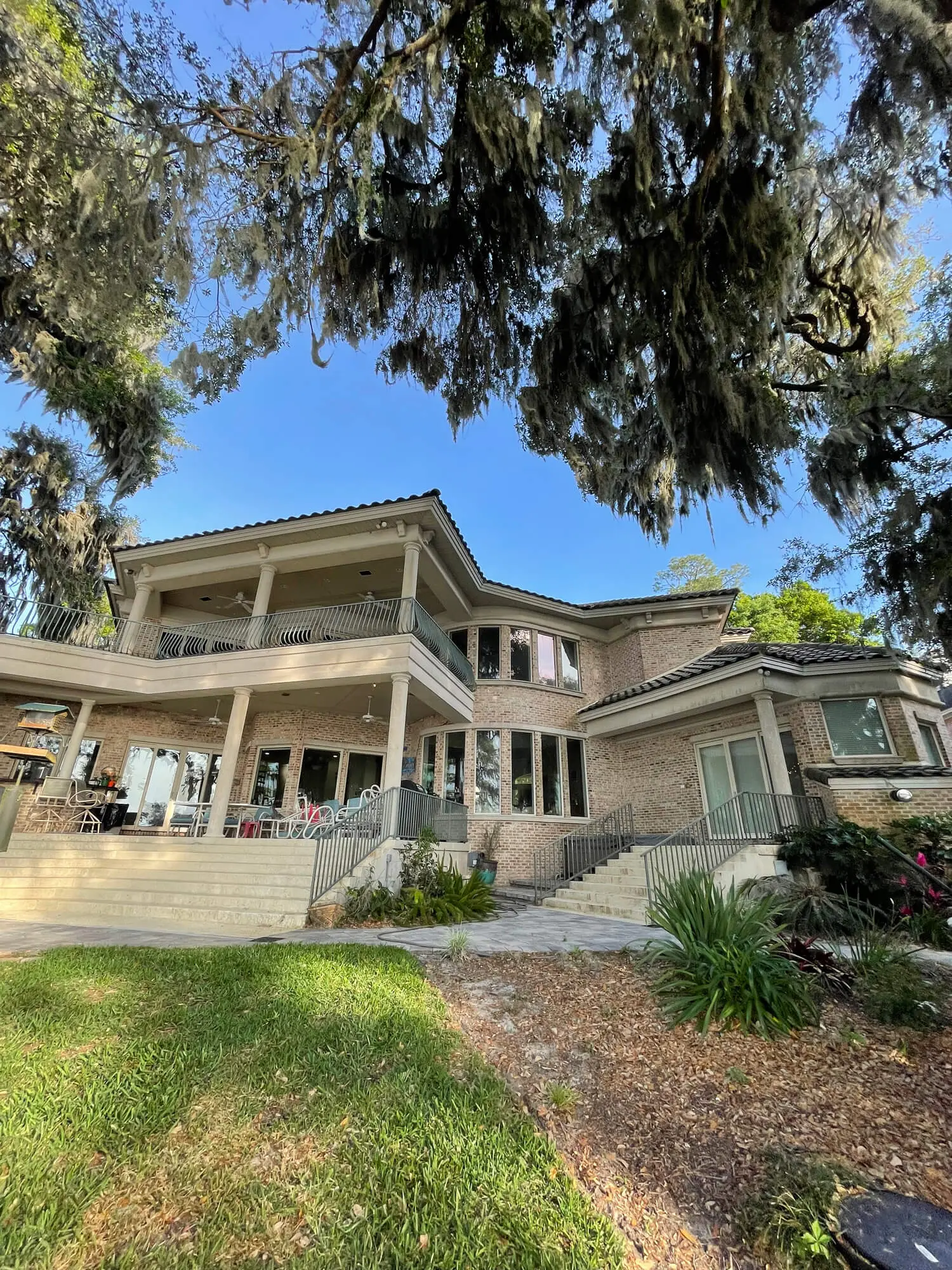 Luxury brick estate featuring sprawling balconies and classic columns perfectly maintained by the expert team at 1st Coast Painting.