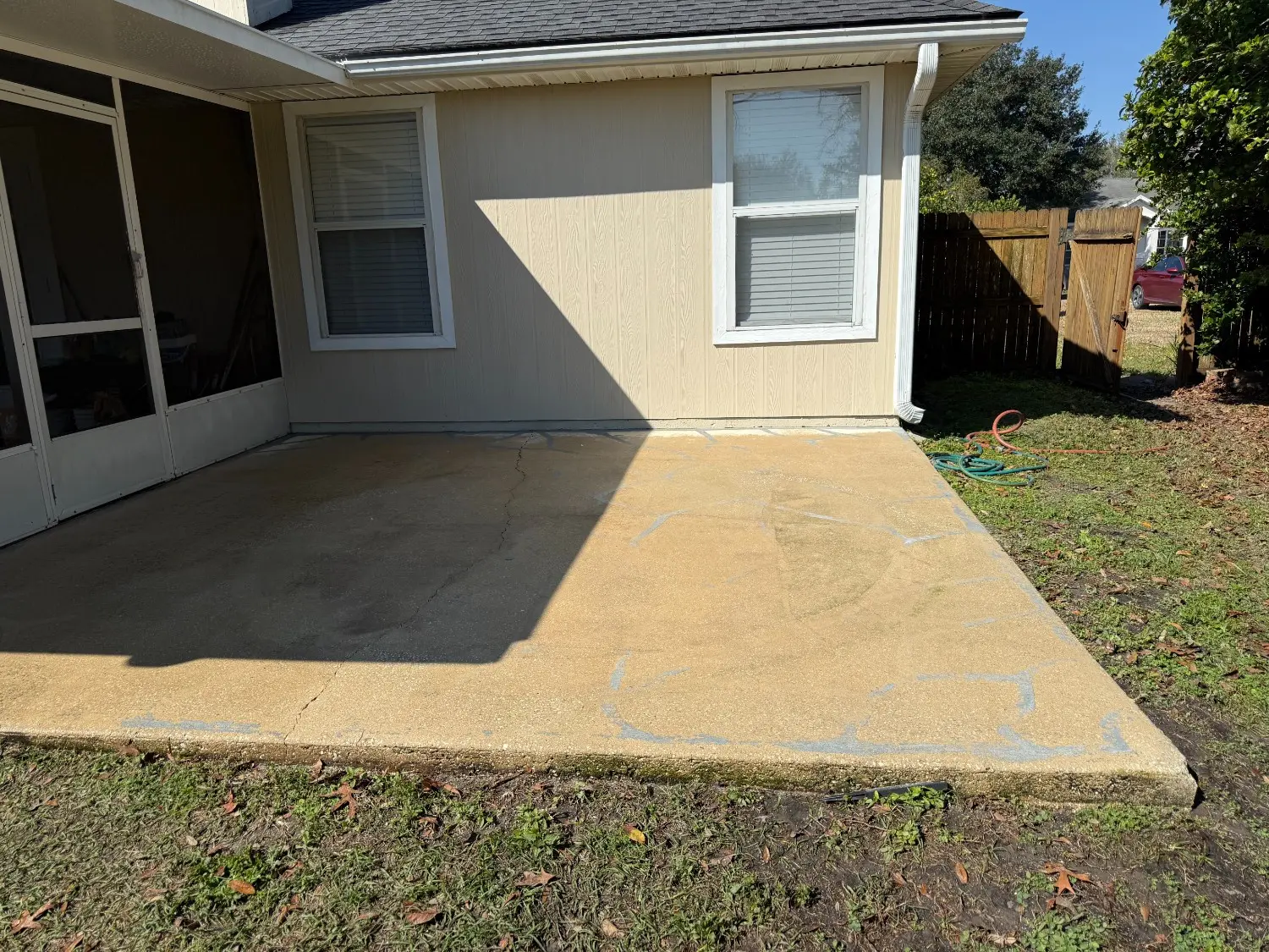 Expertly sealed concrete patio with visible crack repairs by 1st Coast Painting, showcasing durable outdoor surface restoration for residential backyards.