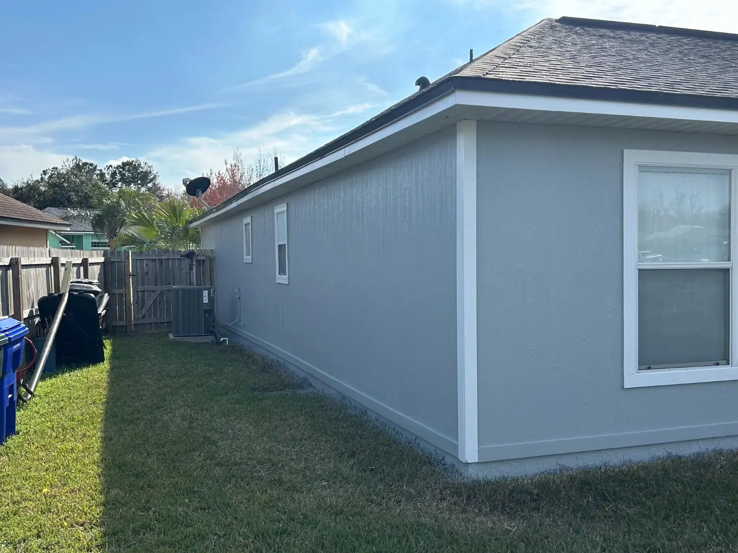 Professional exterior house siding and trim recently updated by 1st Coast Painting in a clean light blue and white color scheme.