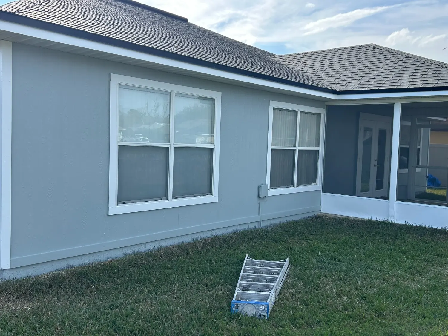 Expert exterior residential painting services by 1st Coast Painting showcasing a freshly finished light blue home with crisp white trim and a professional satin finish.