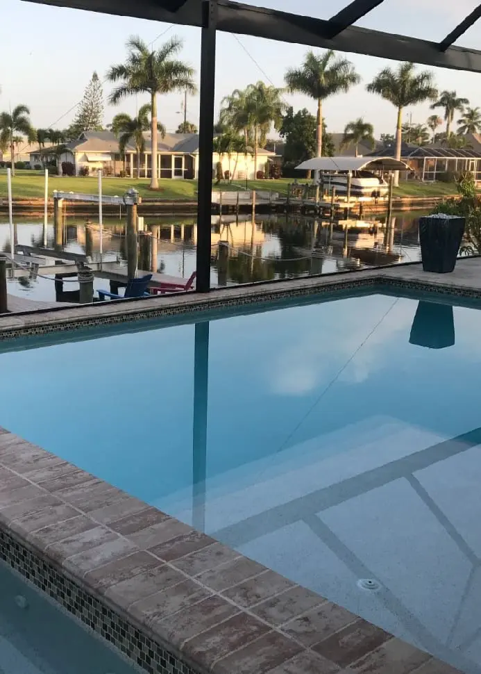 Professional pool deck and waterfront patio featuring expert 1st Coast Painting finishes on exterior surfaces overlooking a scenic canal.