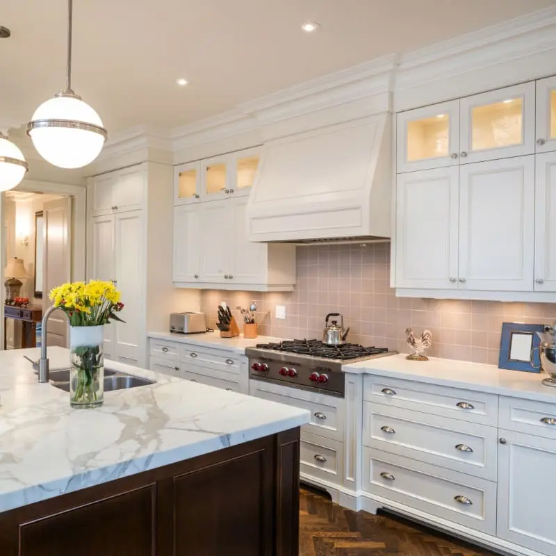 Gourmet kitchen upgrade featuring luxury white cabinetry and a marble island, showcasing the precision interior finishing of 1st Coast Painting.