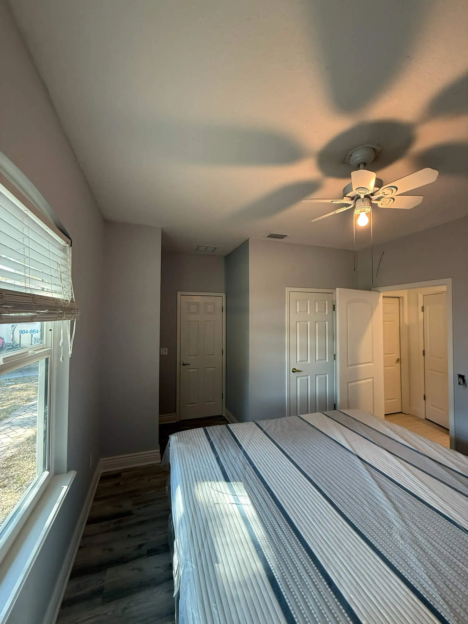 Professional interior bedroom walls refreshed with a smooth, light grey finish by 1st Coast Painting.