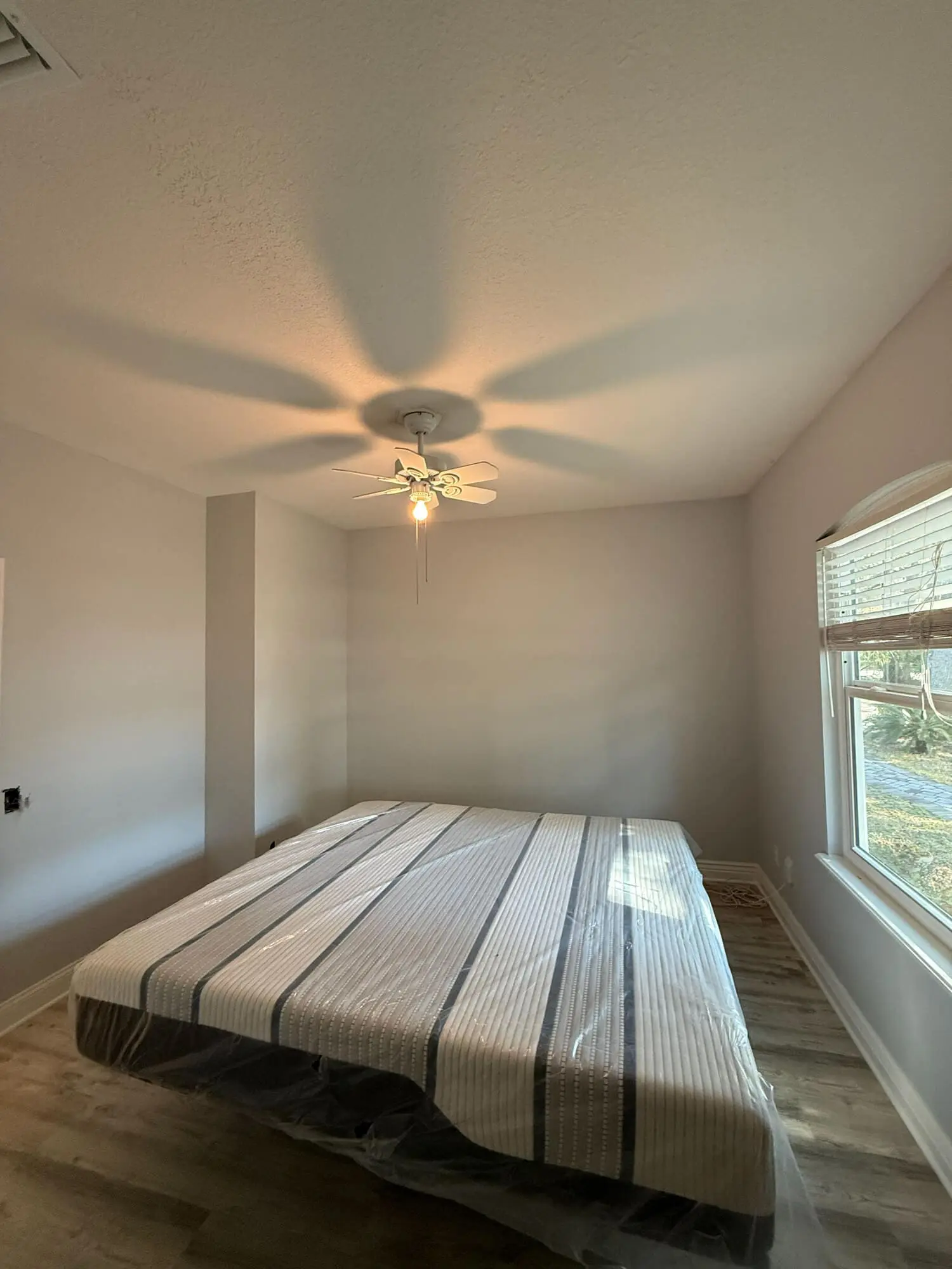 1st Coast Painting expertly finished this bedroom with a smooth, neutral eggshell coat, highlighting clean architectural lines and flawless ceiling integration.